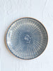 blue and white dinner plate with radial peacock pattern 