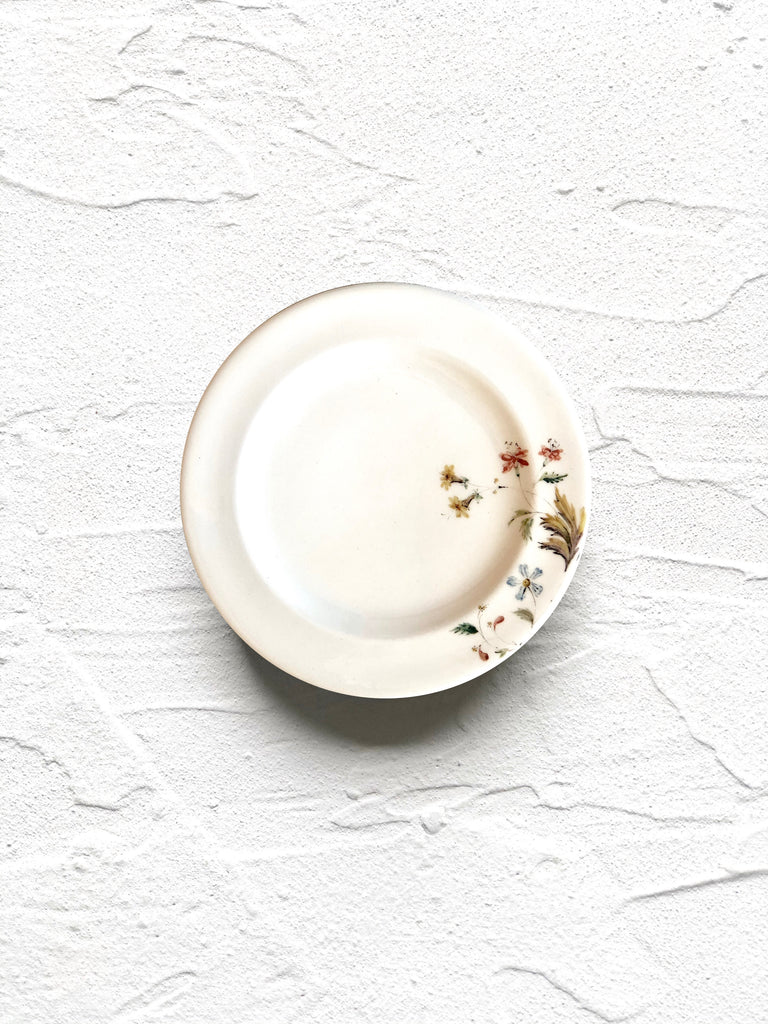 white bread plate with delicate red and yellow floral pattern on rim